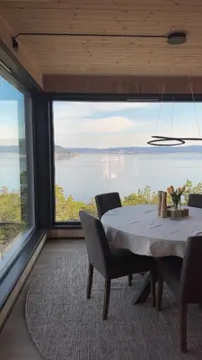 a dining room with a table and a large window at Large modern cabin with a spectacular view! in Grønningen