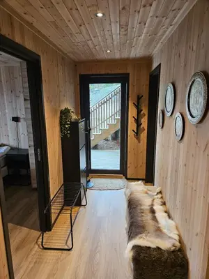 a living room with clocks on the wall and a couch at Large modern cabin with a spectacular view! in Grønningen