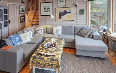 a living room with a couch and a table at Beach Front Home In Omastrand in Gjuvsland