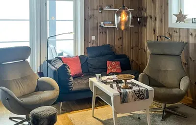 a living room with a blue couch and two chairs at Amazing Home In Eggedal With Sauna in Eggedal