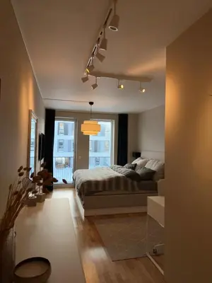 a bedroom with a bed and a large window at Spacious apartment with a great view and parking in Trondheim