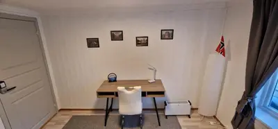 a desk with a chair and a lamp in a room at Storgata 36 in Lillehammer