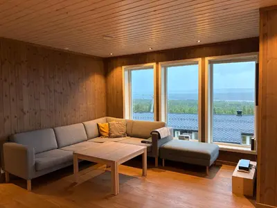 a living room with a couch and a table and windows at Stor leilighet på Bualie, Golsfjellet in Gol