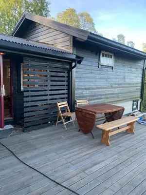 a wooden deck with a table and a bench at Cabin at Kvamskogen with a great view in Kvam