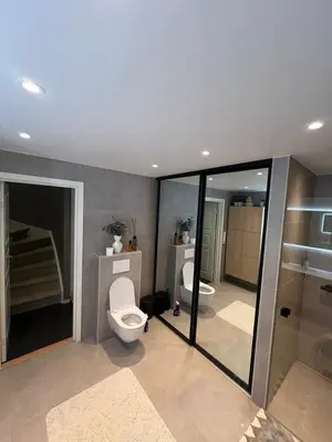 a bathroom with two toilets and a walk in shower at Villa til leie under SKI-VM in Trondheim
