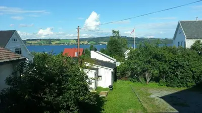 a small white house with a view of a body of water at Trondhjemsvegen in Gjøvik