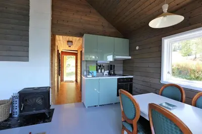 a kitchen with a stove and a table with chairs at Cabin 