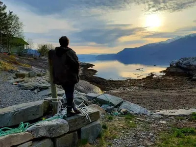 a man standing on a wall looking at the water at Cabin 