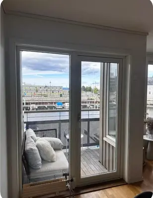 a room with a balcony with sliding glass doors at Apartment in city centre with view of the canal in Trondheim