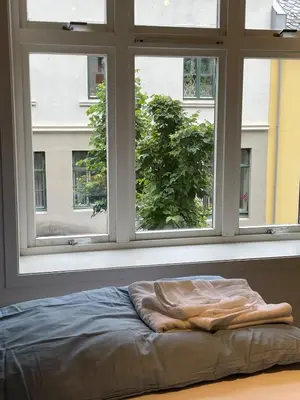 a bed in front of a window with a blanket at Bright Modern Apartment - Prime Location in Ålesund