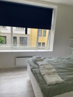 a bedroom with a bed and a large window at Bright Modern Apartment - Prime Location in Ålesund
