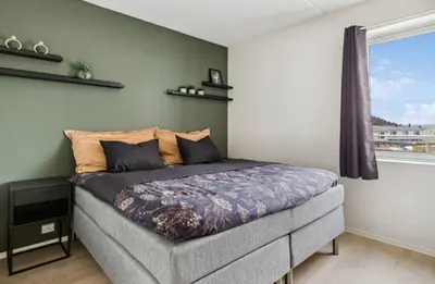 a bed in a room with a window at Fin leilighet for VM in Trondheim