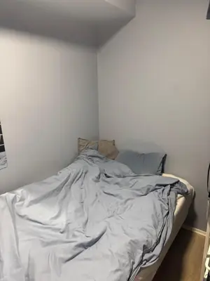 an unmade bed in a white room at Fin leilighet for VM in Trondheim