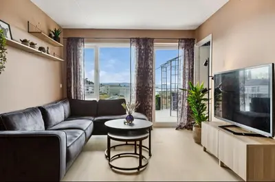 a living room with a couch and a tv at Fin leilighet for Ski VM in Trondheim