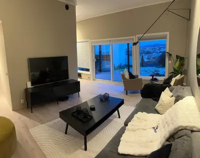 a living room with a couch and a table at Modern apartment with stunning view over city in Trondheim