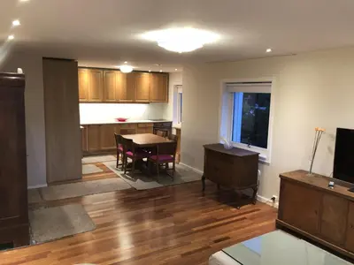 an empty living room with a table and a kitchen at Unique City Center 3-rooms panoramic view with free parking in Trondheim
