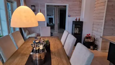 a dining room with a wooden table and chairs at Panorama Cabin - Stunning Mountain Views and Outdoor Jacuzzi Option in Bjorli