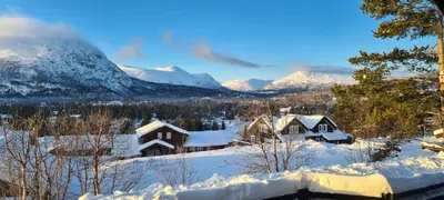 a village covered in snow with mountains in the background at Panorama Cabin - Stunning Mountain Views and Outdoor Jacuzzi Option in Bjorli