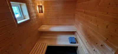 a wooden sauna with a bench in the middle at Panorama Cabin - Stunning Mountain Views and Outdoor Jacuzzi Option in Bjorli