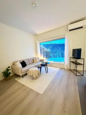 a living room with a couch and a large window at Kolsåsbakken, Granåsen, Nordic Ski World Championships in Trondheim