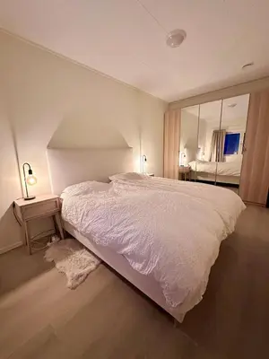 a bedroom with a large white bed and a mirror at Kolsåsbakken, Granåsen, Nordic Ski World Championships in Trondheim