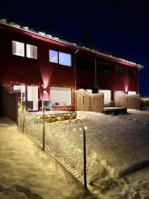 a house with a fence in the snow at night at Kolsåsbakken, Granåsen, Nordic Ski World Championships in Trondheim