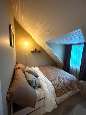 a bed in a room with a roof at City View, stylish loft apartment and Central Location in Trondheim