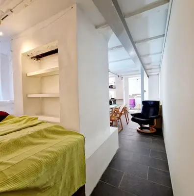 a bedroom with a bed and a chair in a room at Beautiful condo near Bryggen Balcony Fireplace in Bergen