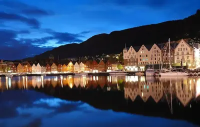 a row of houses on the water at night at Top Floor Close to Grieg Hall and Town Square in Bergen