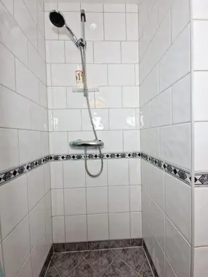 a shower in a white tiled bathroom at Top Floor Close to Grieg Hall and Town Square in Bergen