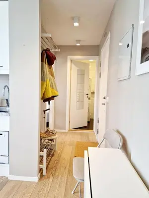 a kitchen with a table and chairs and a hallway at Sleep well in Cozy hideout - Bryggen across the bay in Bergen