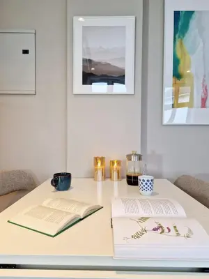 a table with two books and two candles on it at Sleep well in Cozy hideout - Bryggen across the bay in Bergen