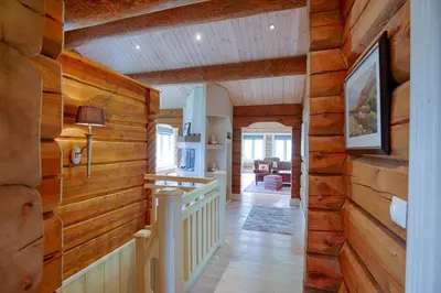 a hallway in a log home with wooden walls at Spacious Cabin With Sauna & Scenic Terrace in Beitostøl