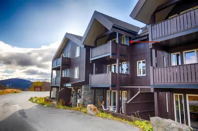 a building with balconies on the side of a road at Central Stay With Balcony, Ideal For Small Family in Beitostøl