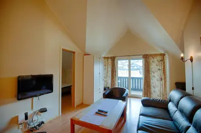 a living room with a couch and a table at Central Stay With Balcony, Ideal For Small Family in Beitostøl