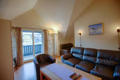 a living room with a couch and a table at Central Stay With Balcony, Ideal For Small Family in Beitostøl