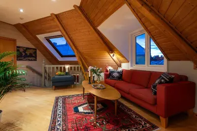 a living room with a red couch and a table at Cozy downtown apartment in Trondheim