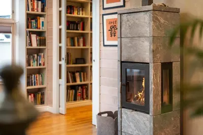 a fireplace in a living room with books at Cozy downtown apartment in Trondheim