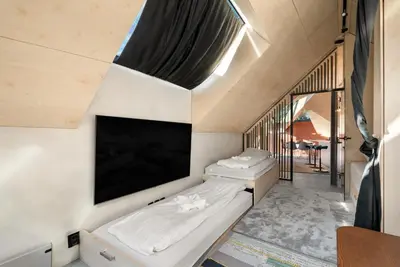 a room with two beds and a flat screen tv at Bryggen Penthouse I NEW 2021 in Bergen