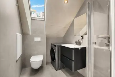 a small bathroom with a toilet and a sink at Bryggen Penthouse I NEW 2021 in Bergen