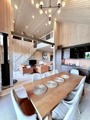 a dining room with a wooden table with white chairs at Holiday Cabin with Hot Tub and Billiard Table in Tyndrom