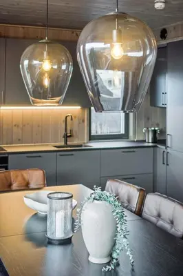 a kitchen with a table with two large glass pendant lights at Hafjell Front 220B 8pers Ski InOut, Downhill bike in Hunder