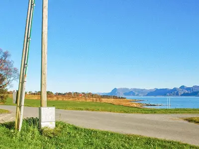 a pole on the side of a road next to a lake at 6 person holiday home in Fjørtoft in Fjørtoft