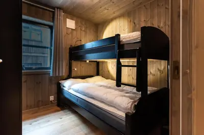 a bunk bed in a room with wooden walls at Trysiltunet 6A in Trysil