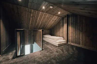 a small room with a bed in a wooden cabin at Modern Mountain Cabin - Outdoor Hot Tub - 8 Beds in Torpo