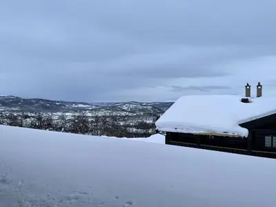 a snow covered roof of a house on a snowy hill at Family-Friendly 2-Bedroom With Terrace And Sauna in Beitostøl