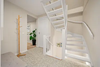 a white spiral staircase in a white room at Marken Townhouse NEW 2025 in Bergen