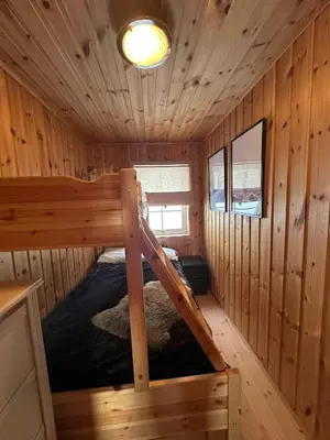 a bedroom in a log cabin with a bunk bed at Cabin at Furutangen - 3 bedroom family cabin in Åmot