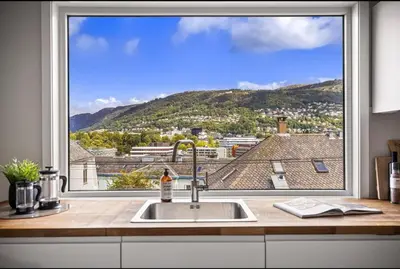 a kitchen window with a view of a mountain at Central 2 story modern apartment in Bergen