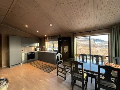 a kitchen and dining room with a table and chairs at Hjertebo by Norgesbooking - cabin at Spåtind in Nord Torpa